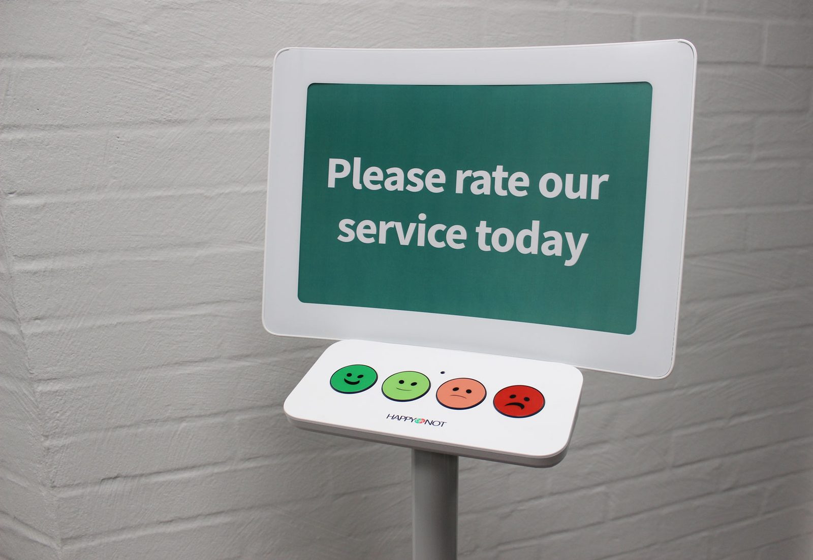 Customer feedback terminal asking to rate the service with smiley-face buttons