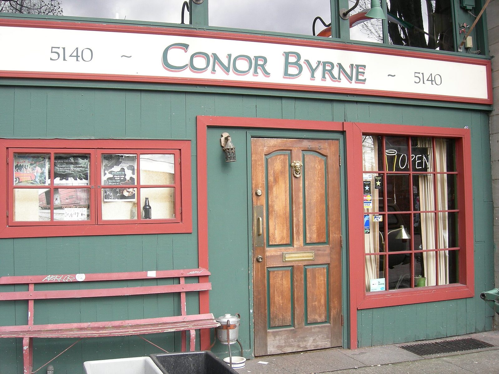 Storefront of a neighbourhood music venue with a red door and an open sign