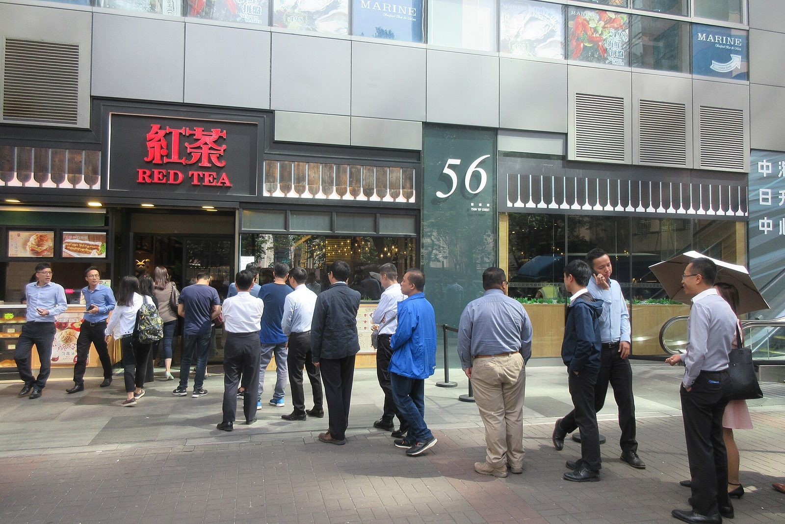 Long lunchtime queue of customers outside a popular restaurant
