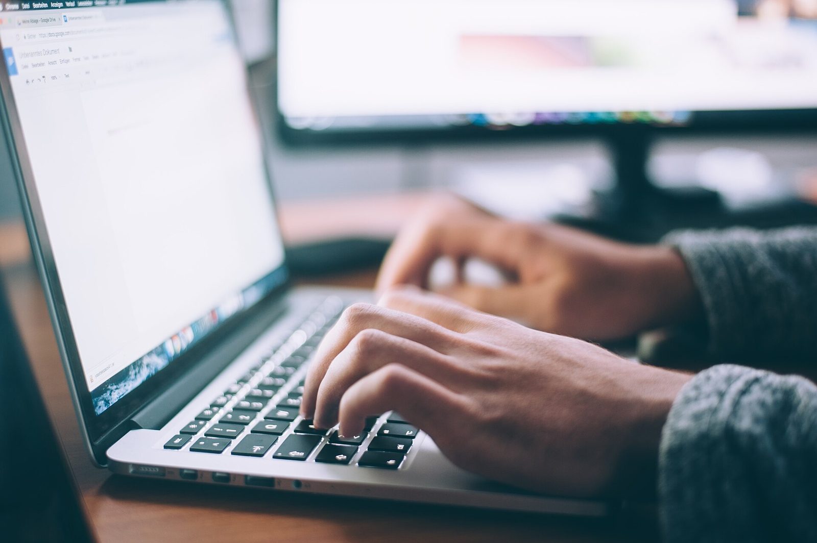 Hands on a laptop keyboard while reading a web page